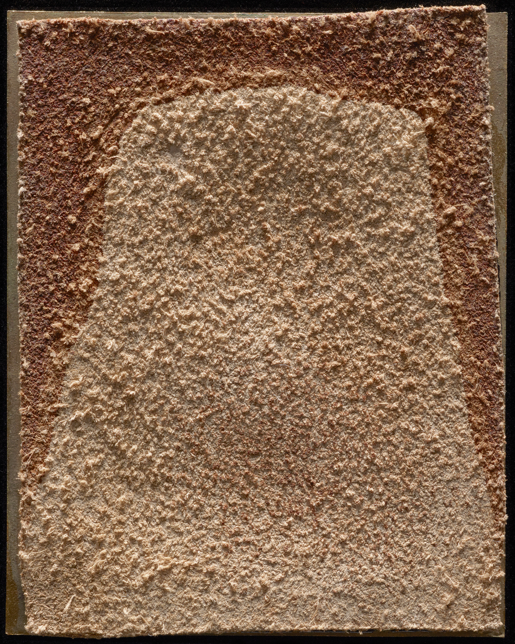 Back of a leather photograph with a dark stain along the top left and top right edges.