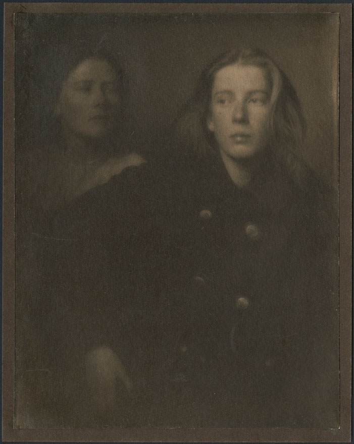 Two young girls both looking away from the camera in a dark room.