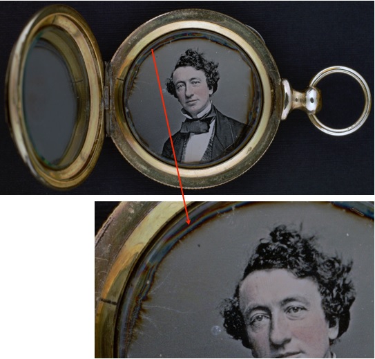 A brass locket of a man with blue and brown tarnish around the edges.