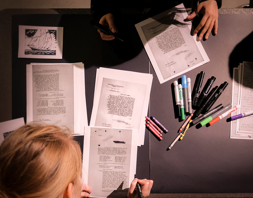 Participants at Halifax’s Nocturne: Art at Night festival create poems by obscuring and highlighting words in reproduced LAC documents. Photo: Harbour City Imagery