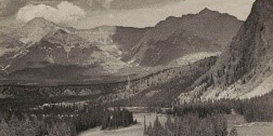 Black and white photo of a daytime scene showing, from bottom to top, an observatory with pool and bathers, a coniferous valley with a meandering river running through it, and a panorama of snow-capped mountains