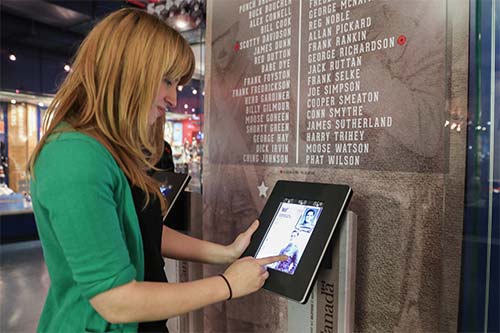 To commemorate the centennial anniversary of the start of the war, LAC contributed copies of the Canadian Expeditionary Force Attestation Papers and service files of over 30 Hockey Hall of Fame inductees. Curator Carolyn Cook looks at one of these files at one of the four interactive stations furnished by LAC for the exhibition.