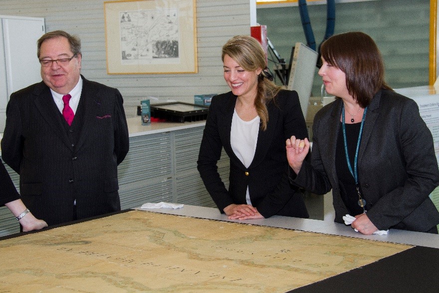 The Honourable Mélanie Joly, Minister of Canadian Heritage, and Guy Berthiaume, Librarian and Archivist of Canada, learn some interesting details about an 1834 map of Montreal from Early Cartography Archivist Isabelle Charron.
