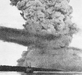Photo noir et blanc d'un gros panache de fumée produit par la collision entre les navires Mont-Blanc et Imo, ayant entraîné l'explosion du Mont-Blanc dans le port de Halifax.